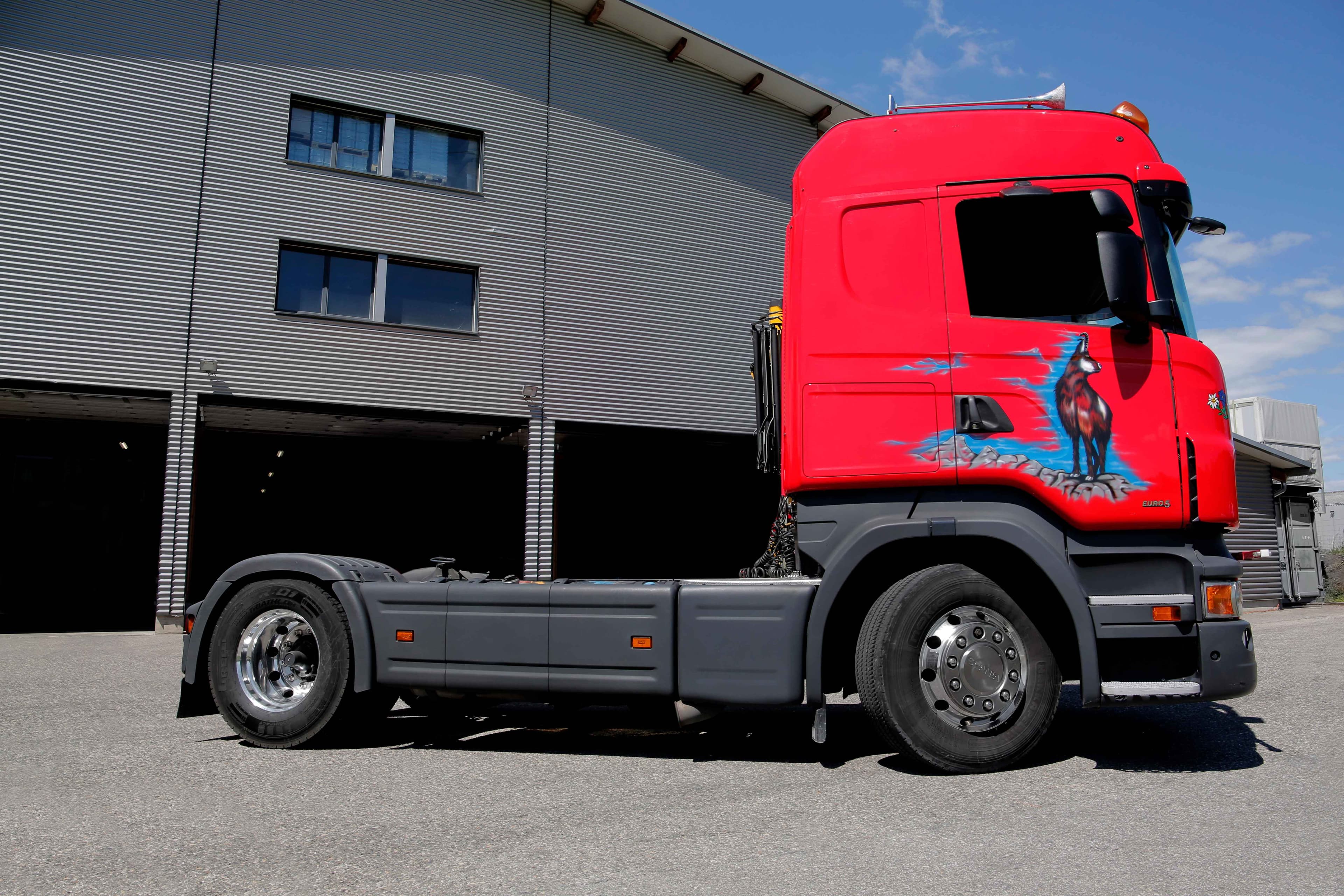 GEMSI Sattelschlepper - Roter Scania Truck mit Gemsen-Design vor Industriegebäude